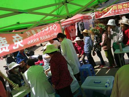 热闹的集市上，看病的市民自觉地排起了队